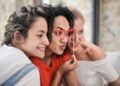 Three women enjoying a playful moment with heart-shaped glasses, symbolizing friendship and fun.